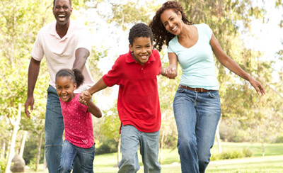 photo of a family running and playing in a park